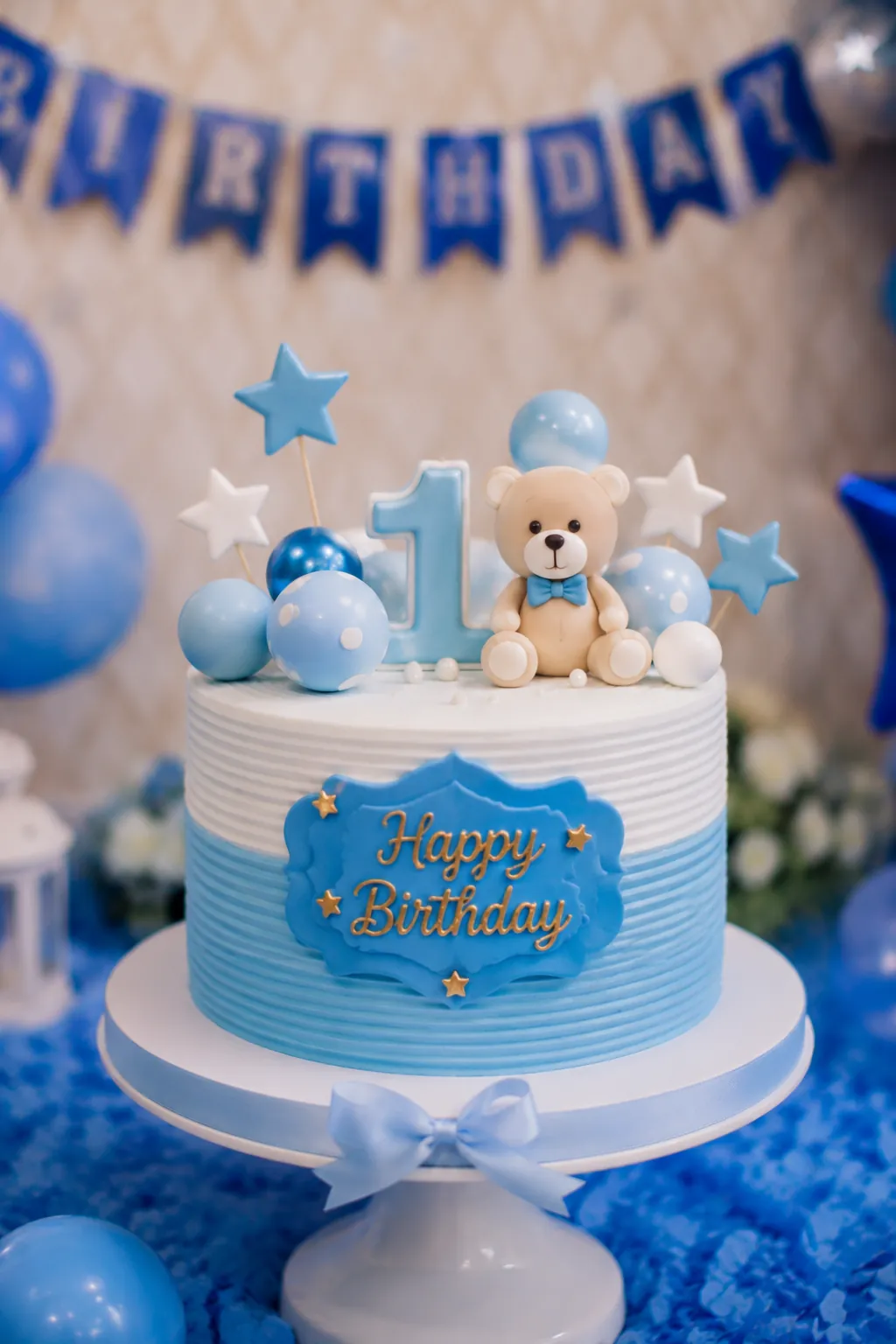 Blue-themed first birthday cake decoration with balloons for a baby boy in Delhi by DesignInfo Photography